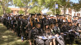 Rows of students in caps and gowns during a commencement ceremony.